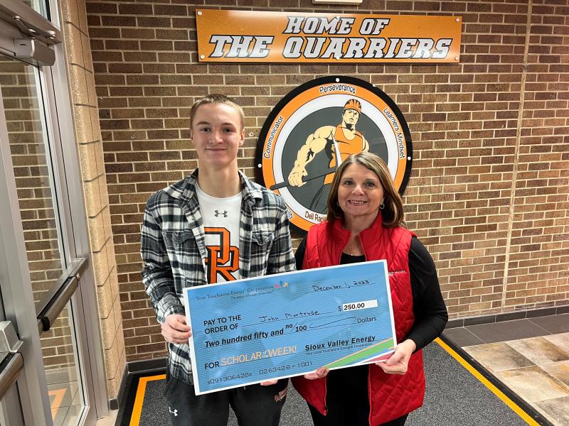 John Montrude receives a $250 Touchstone Energy Scholar of the Week check from Sioux Valley Energy's Lori George.