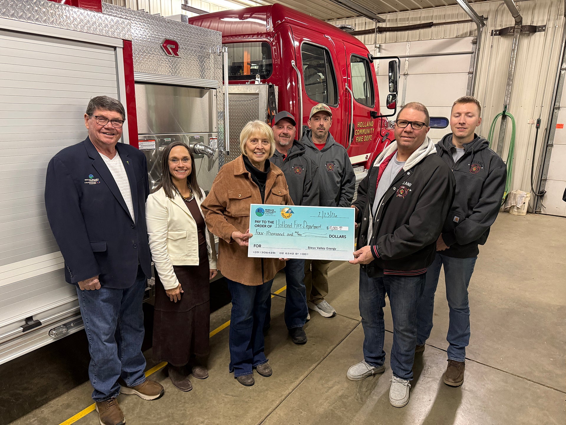 Sioux Valley Energy Director Gregg Johnson, SVE Vice President of Public Relations Carrie Vugteveen and Operation Round Up® Board member Julie Stevens present a check to members of the Holland Community Fire Department: Jason Borman, Ryan LaBrune, Merle Zeinstra, and Holdan Surat.