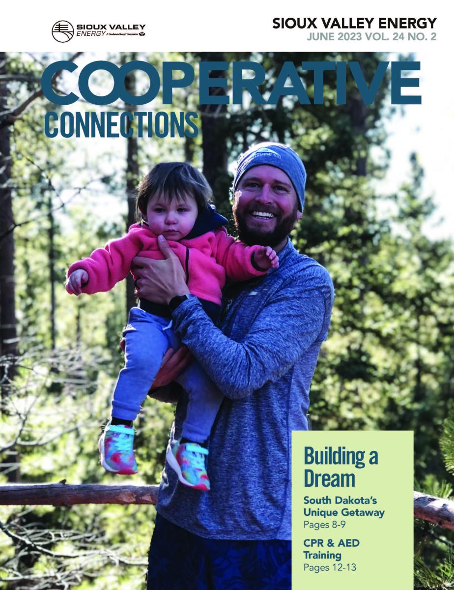 June 2023 magazine cover of Man holding a child