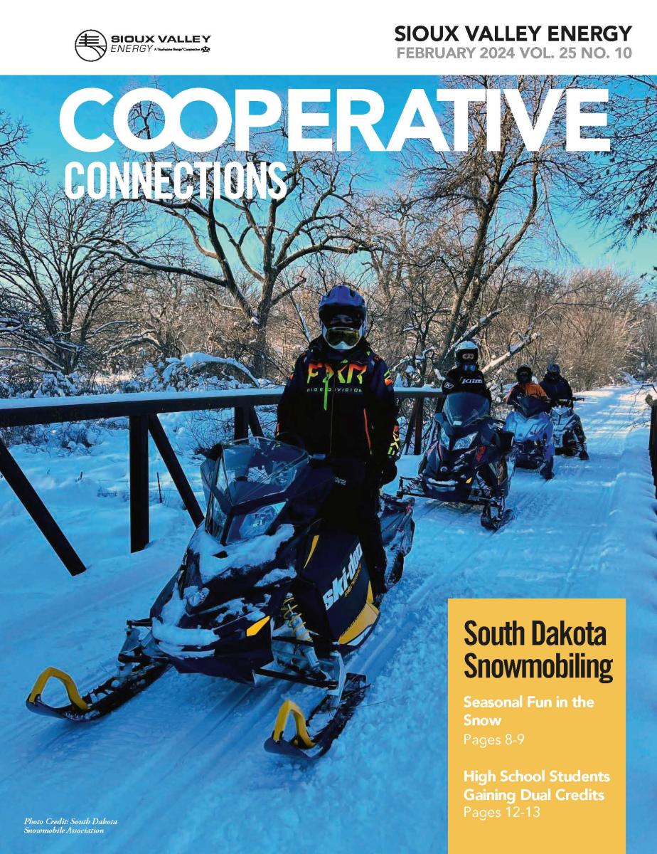 February 2024 magazine cover showing four snowmobilers on sleds crossing a bridge